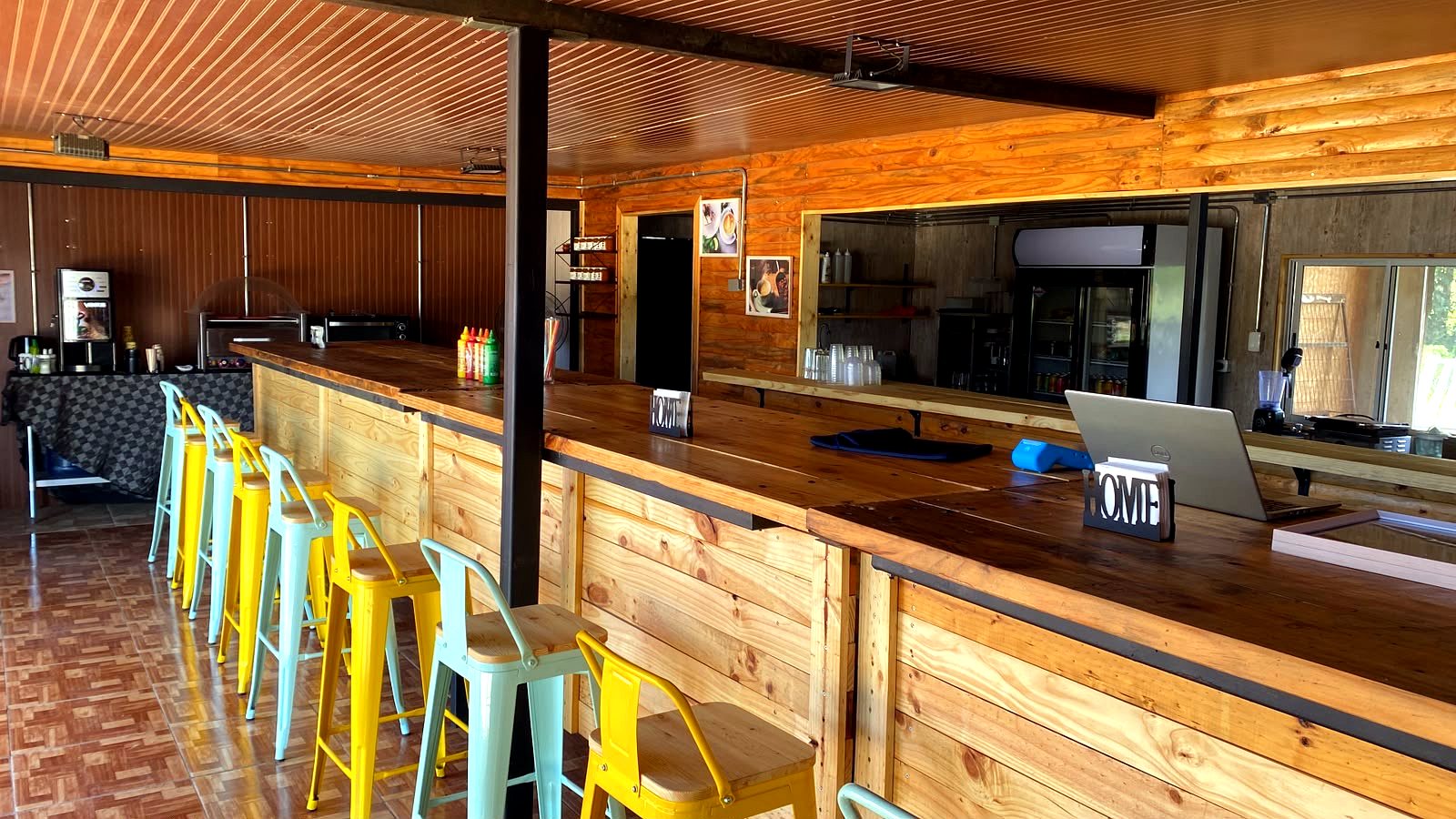 Barra de atención de Amore Cafetería con banquitos amarillos y menta