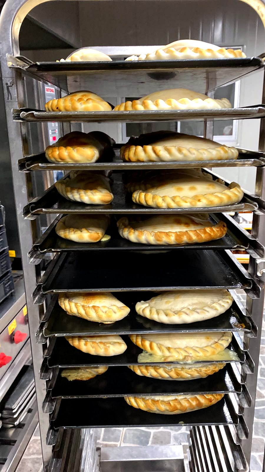 Coche de empanadas recién horneadas en la cocina de Amore