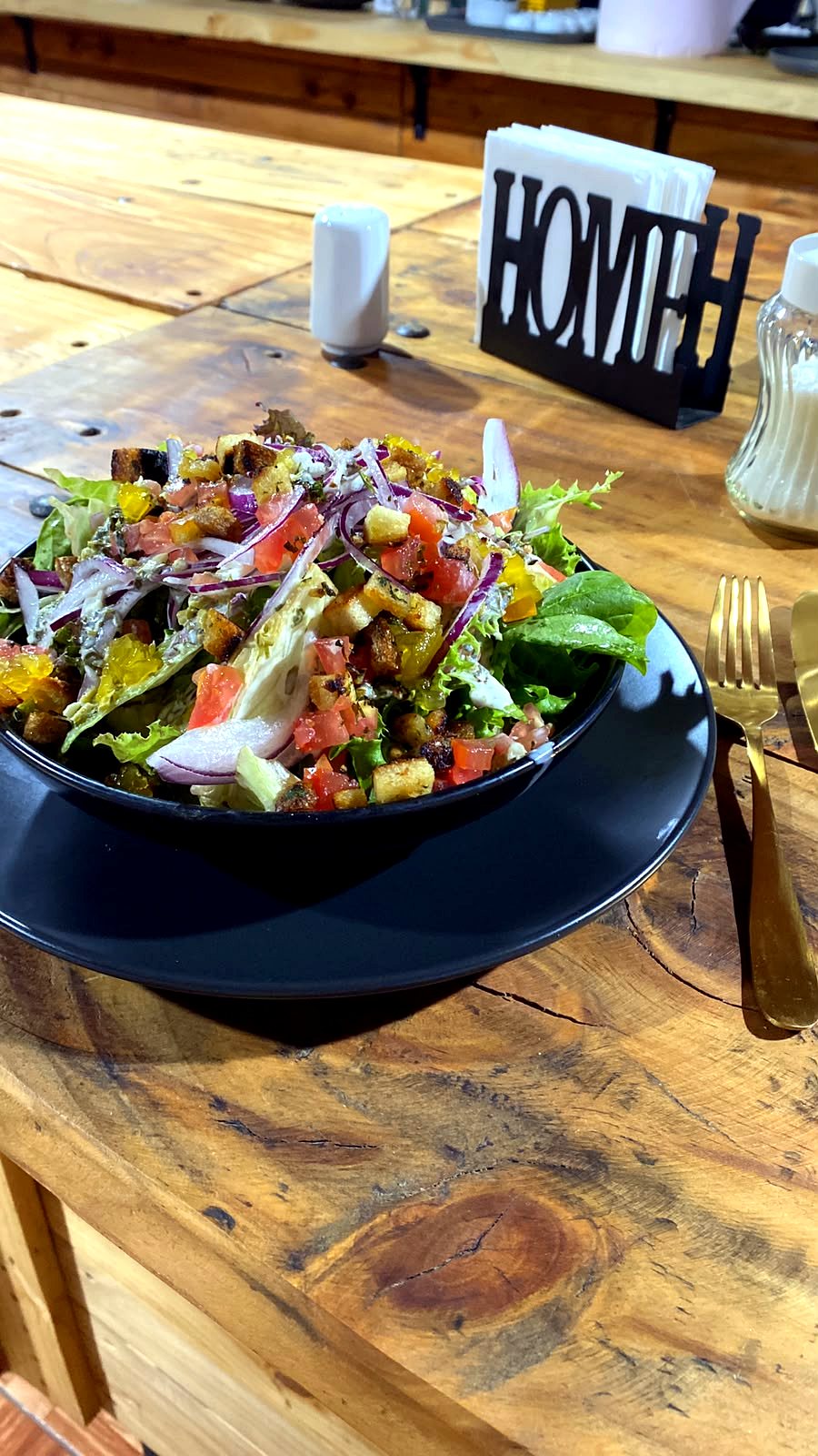 Ensalada fresca con crotones, tomate y cebolla morada