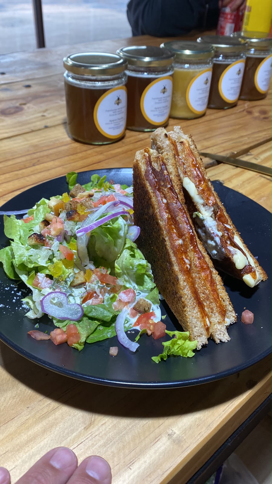 Sándwich caliente con queso fundido y ensalada fresca, preparado al momento en Amore Cafetería